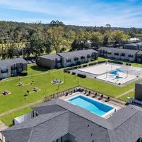 A large building complex with a swimming pool in the middle.